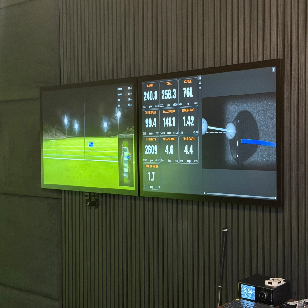Two iiyama ProLite TF4339AS-B1AG touchscreens installed in a high-end commercial golf simulator setup displaying TrackMan analytics.